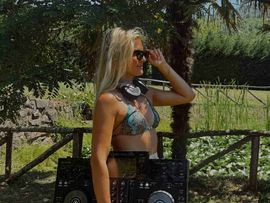 Ricarda Mercedes in einem Park mit Sonnenbrille und DJ Tablet in der Hand.