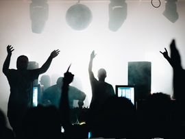 Menschen feiern vor einer Bühne eines Konzerts