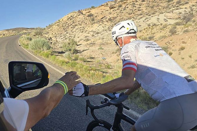 Kurt Matzler auf Rennrad bekommt Trinkflasche