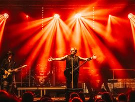 Musikshow mit roten Lichtern und Musikern davor