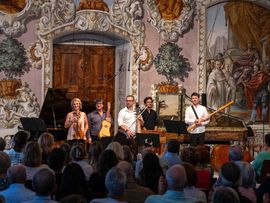 Musiker stehen mit ihren Instrumenten vor einem Publikum