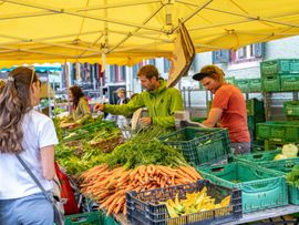 Wochenmarktstand mit Gemüse und Kunden