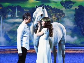 Ein Mann und eine Frau sehen sich an, ein Pferd steht dazwischen