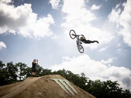 Mountainbiker springt mit Rad über Schanze