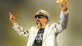 Ein Mann im weißen Piloten-Kostüm steht auf der Bühne