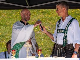 Ein Pfarrer und ein Mann in Lederhosen