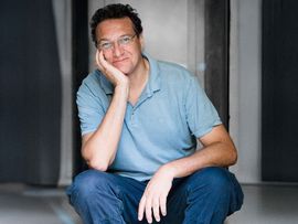 Karim El-Gawhary sitzend vor einer offenen Türe