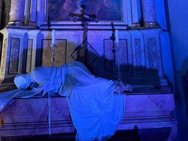 Frau die in einer Kirche mit blauem Licht liegt