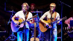 2 Sänger mit Gitarre vor Mikrofon auf Bühne