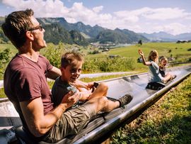 Familie auf Sommerrodelbahn Zahmer Kaiser