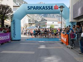 Teilnehmer einer Laufveranstaltung laufen über die Startlinie