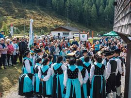 Große Menschenmenge verfolgt einen Auftritt im alpinen Dorf.