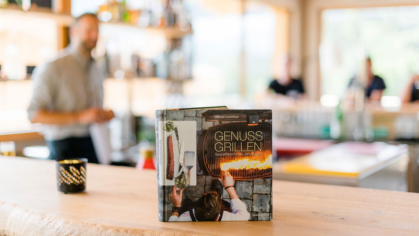 ein Buch mit dem Titel "Genuss Grillen" steht auf dem Tisch