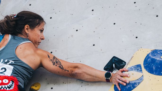 Jasmin Plank klettert eine Wand hinauf und hält sich fest