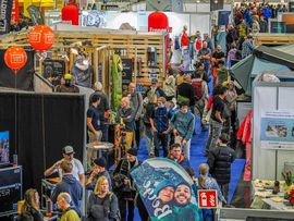 Menschenmenge die durch die Stände der Alpinmesse schlendert.