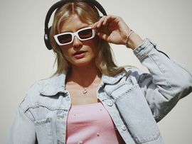 Ricarda Mercedes mit rosa Sonnebrille und Kopfhörern ausgestattet.