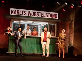 Besucher am Würstelstand im Theaterstück "Würsteloper" 
