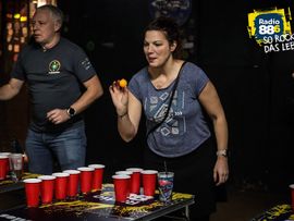 Besucher nehmen bei der Veranstaltung an einem Becherspiel teil.
