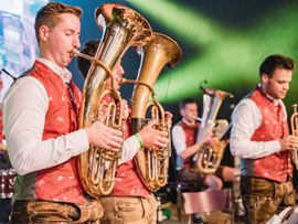 Mehrere Männer spielen Blasinstrumente auf Bühne