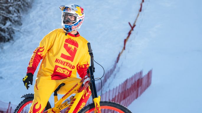 Mann in einem gelben Mountainbike-Anzug sitzt auf dem Bike