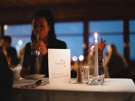 Dame mit Glas und Trinkrohr an einem gedeckten Tisch auf der Seegrube