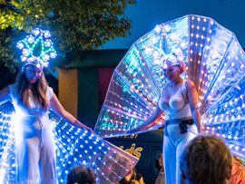 Zwei Frauen tanzen in leuchtenden Kostümen des nachts