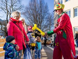 Ein Clown verschenkt Luftballonfiguren beim Kinderfasching in Reutte