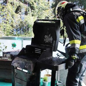 ein Feuerwehrmann der einen brennenden Grill gelöscht hat