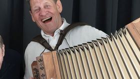 Ein Mann spielt ein Akkordeon, ein anderer steht daneben