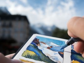 Eine Person zeichnet die Umgebung auf einem Skizzenblock