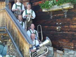 Eine Gruppe an Volksmusikanten auf einer Hütte
