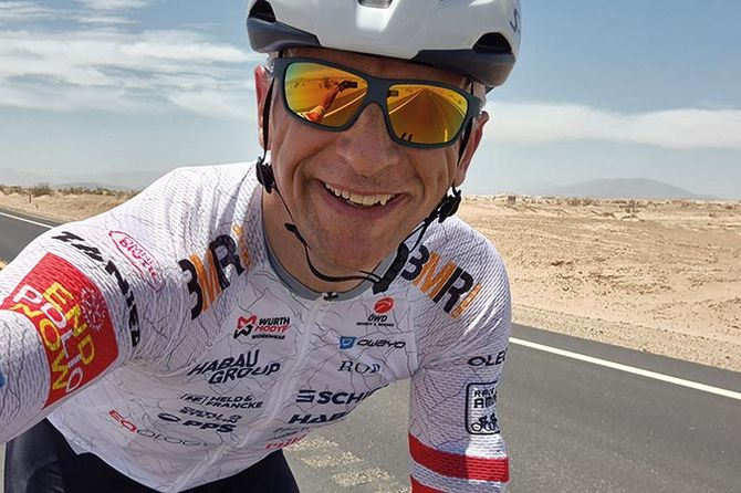 Kurt Matzler auf Rennrad lacht in die Kamera