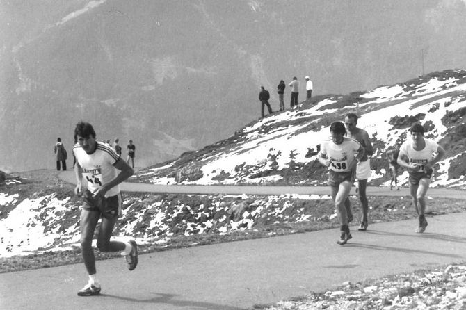 Ein altes Schwarz-Weiß Foto von einer Gruppe die einen Berg hinauf läuft
