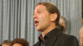 Mann im schwarzen Hemd singt