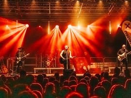 Musikshow in roten Lichtern mit Musikern davor