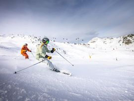 Ski Fahrer, die einen Berg herunterfahren