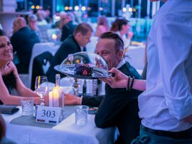 Ein Kellner bringt Essen an den Tisch