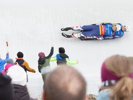 Foto eines Einsitzers in der Eisbahn mit Publikum