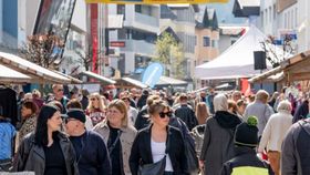 Menschen laufen durch eine Straße mit Ständen