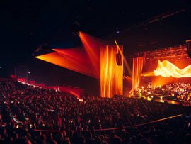 Bild von einem großen Saal mit einer beleuchteten Bühne