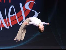 Mensch in weißem Anzug macht einen Salto