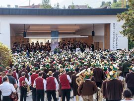 ©Ludwig Auer Großer Festakt mit zahlreichen Musikkapellen vor der Bühne der Musikkapelle Sautens, umgeben von einem großen Publikum.