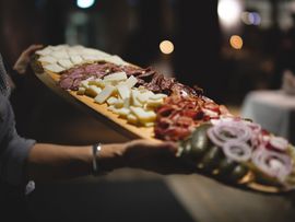 Reich belegtes Holzbrett mit Käse, Speck, Fleisch und eingelegtem Gemüse beim Törggelen.
