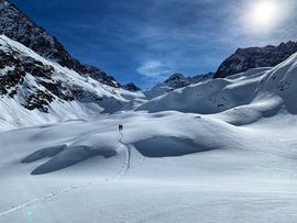 Zwei Tourengeher am Aufstieg über tiefverschneite Hänge zum Bachfallenkopf