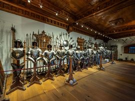 Ein Museumsraum voller historischer Ritterrüstungen und Waffen.