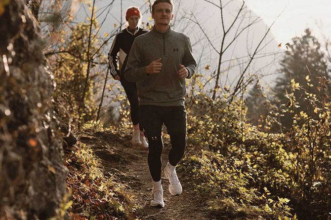 Zwei Personen joggen durch den Wald
