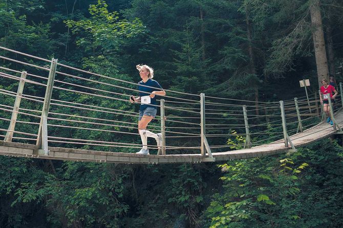 zwei Personen rennen über eine Hägebrücke