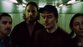 Vier Männer stehen in einem dunklen Gang und schauen Richtung Kamera