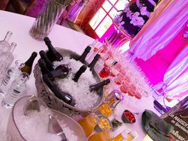 Ein gedeckter Tisch mit einer Eisschale und Sektflaschen