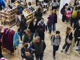 Ausstellungsregale mit Produkten und stöbernde Besucher